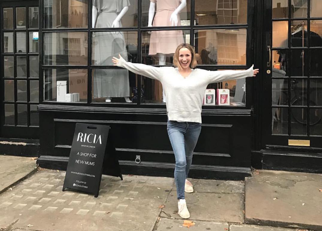 Woman standing next to her pavement sign.