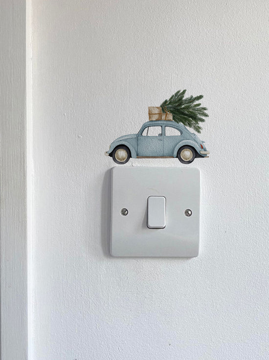 Blue Car Carrying a Christmas Tree Light Decoration