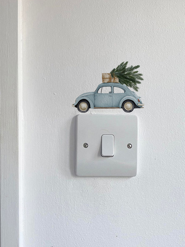 Blue Car Carrying a Christmas Tree Light Decoration