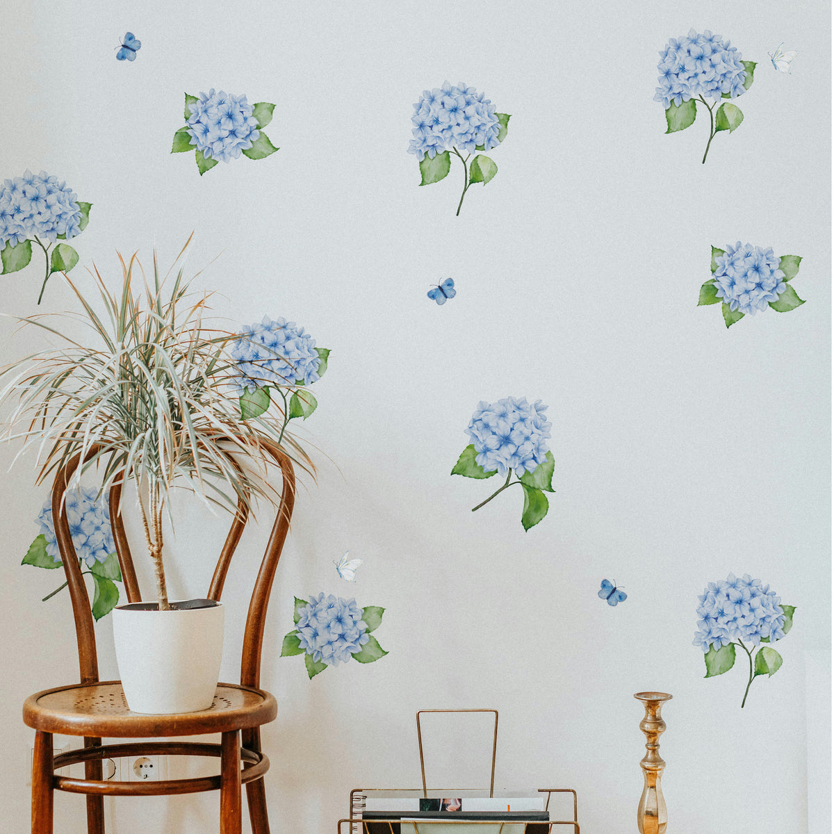Wall with blue hydrangea and butterflies wall decals and a wooden chair with a plant.