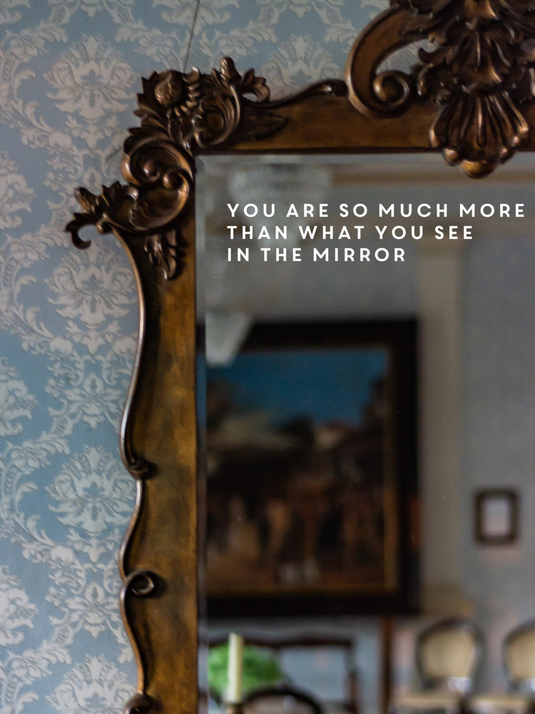Decorative mirror with ornate frame against a wall with text overlay.