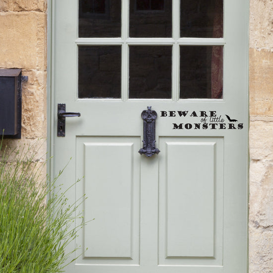 Beware of Little Monsters Vinyl Door Sticker. Shows it in black vinyl on a light grey door. Perfect for a Halloween decoration. 