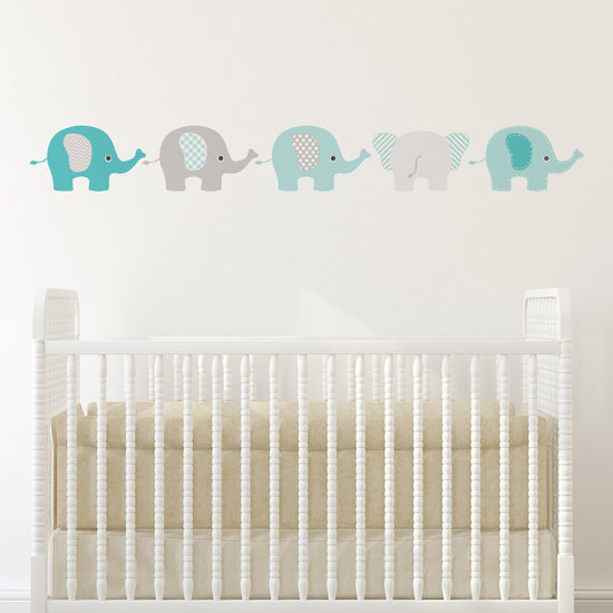 Blue Elephants decals Wall Stickers. Image shows 5 small elephant stickers in blue and grey on a white wall. Perfect for a nursery or children&