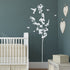 Blossom Tree Wall Sticker. Image shows the sticker in white vinyl on a dark green wall, the sticker includes the blossom tree, butterflies and a bird sticker. Perfect for decorating bedrooms or living rooms.