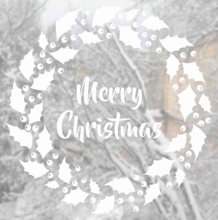 White Merry Christmas window sticker surrounded by a holly wreath