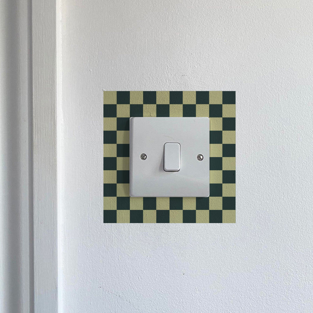 Black &amp; Yellow Chequred_Light_Switch_Decals on a white wall.