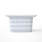 A medium rectangular storage bin, featuring a light blue and white harlequin diamond pattern with small red dots, shown on a clean white background.