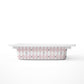A small rectangular drawer with a pink and white harlequin diamond pattern on the sides, shown from a side profile against a clean white background.