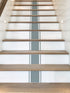 Staircase with wooden steps and a gray stripe on a white wall