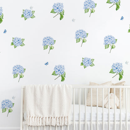 Nursery room with white crib and blue hydrangea wall decals with butterflies on a white background