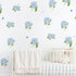 Nursery room with white crib and blue hydrangea wall decals with butterflies on a white background