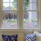 Decorative Hydrangea window Sticker on a window, with pillows on a couch below.