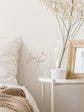 Nursery room with decorative elements including a framed picture, vase with dried flowers, and &