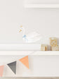 Decorative swan figure with a crown on a shelf.