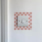 Light Pink Chequred_Light_Switch_Decals on a white wall