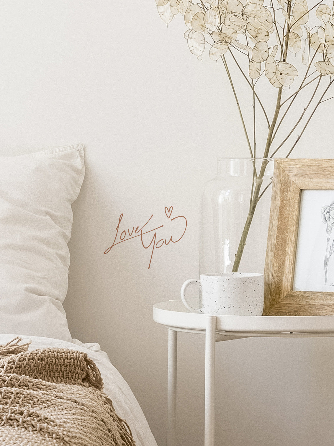 Nursery room with decorative elements including a framed picture, vase with dried flowers, and &