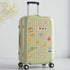 Green suitcase with New York travel-themed stickers on a light gray background