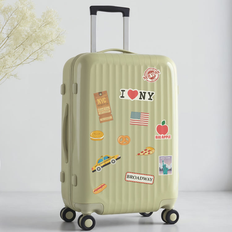 Green suitcase with New York travel-themed stickers on a light gray background