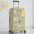 Green suitcase with Paris travel-themed stickers on a light gray background