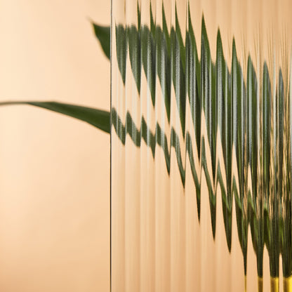Close-up of a green leaf against a beige background with the Reeded Window Film