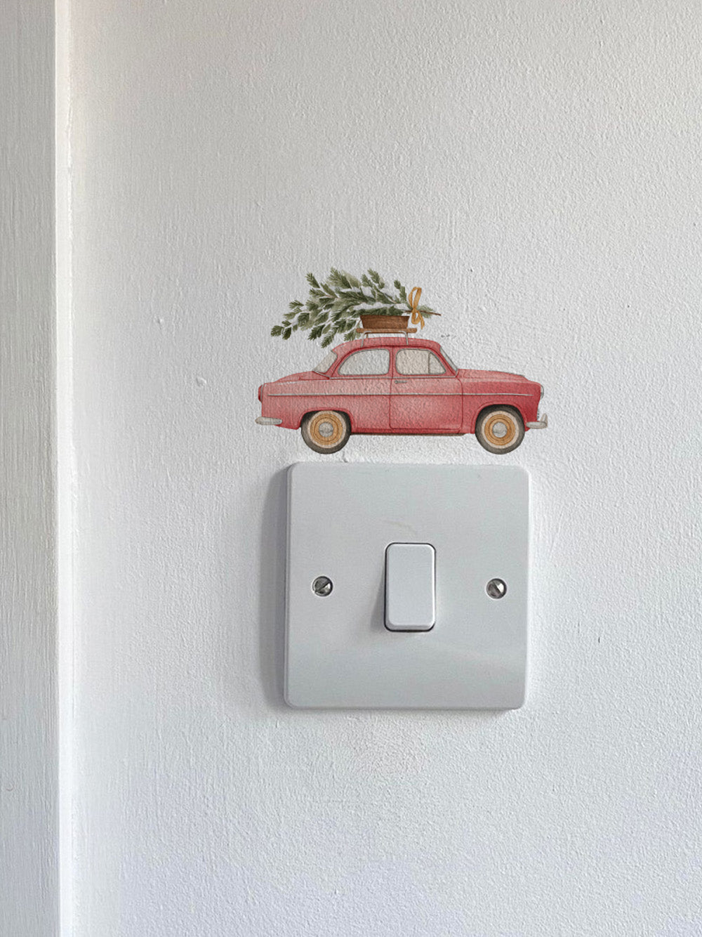 Red Car Carrying a Christmas Tree Light Decoration