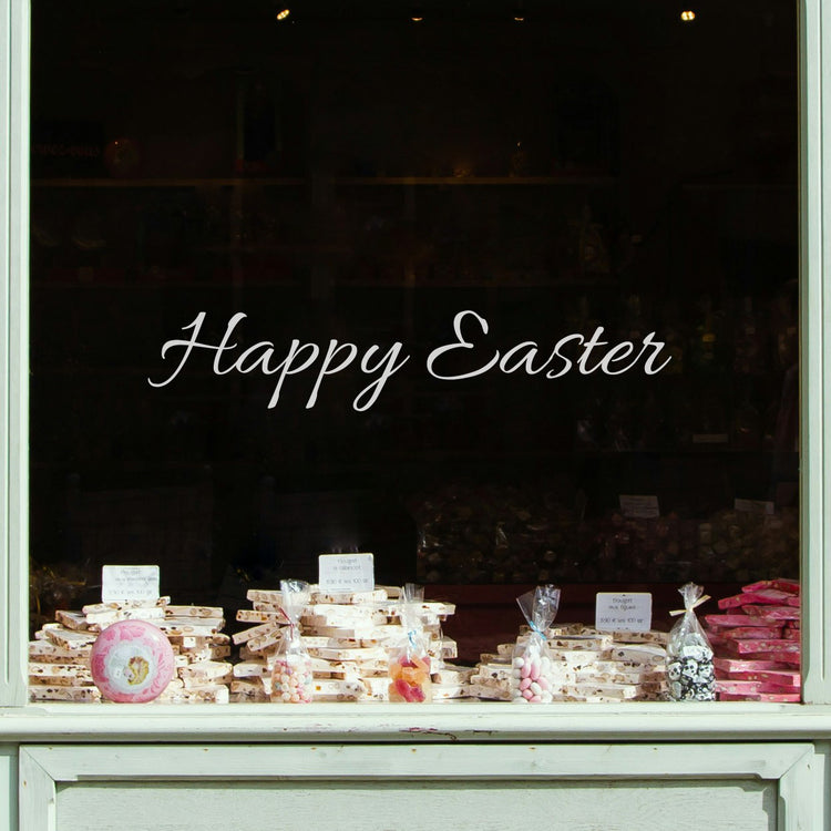 Display of Easter-themed treats in a store window with script writing of &