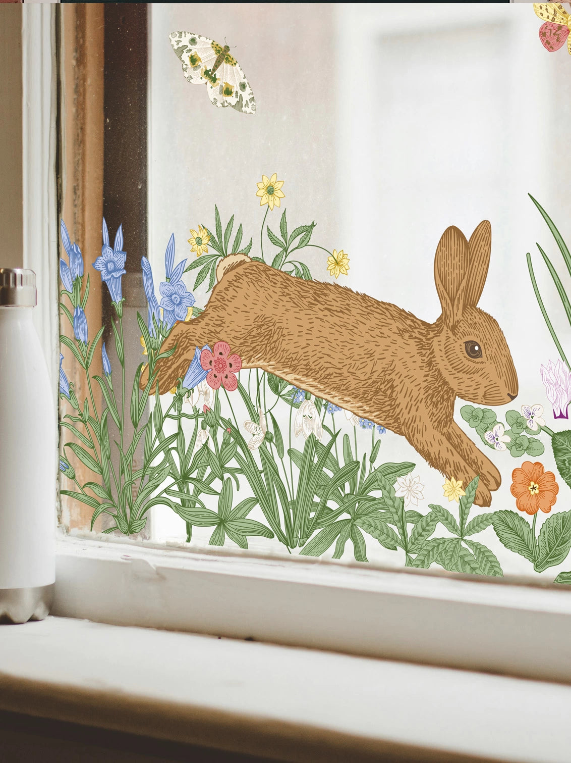 white window frame with a flowers, a bunny and butterfly window cling