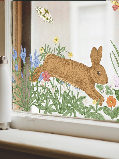 white window frame with a flowers, a bunny and butterfly window cling