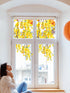A image depicting a window with yellow blossom window sticker decals, with a person sitting on a windowsill, looking out at the window.