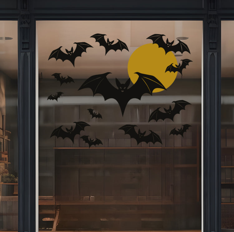 Decorative window with black bats and a gold moon on a dark background