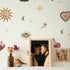 Wall with decorative stickers of a sun, moon, stars, and flowers above a framed photo of a couple.