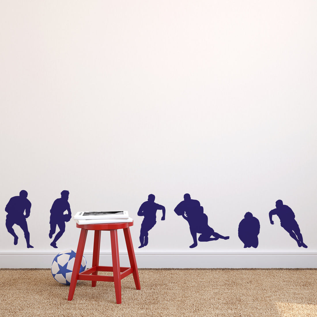 A set of 6 rugby player silhouettes in Colbat Blue applied as wall stickers on a wall, with a small red stool and a soccer ball to the bottom left.