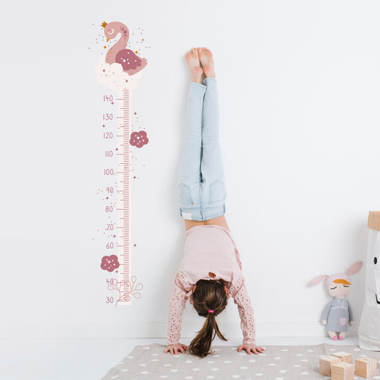 Boho Swan Wall Sticker Height Chart. Image shows a white height chart with a dark pink height scale and light pink swan at the top. Perfect for a nursery or children&