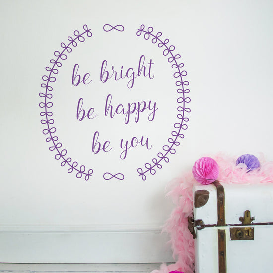 Be Bright, Be Happy, Be You Wall Sticker. Shown in purple on a white wall. Perfect for a children&