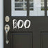 Boo Halloween Vinyl Door Sticker. Image shows it in white vinyl on a black door. The perfect product for a small Halloween decoration.